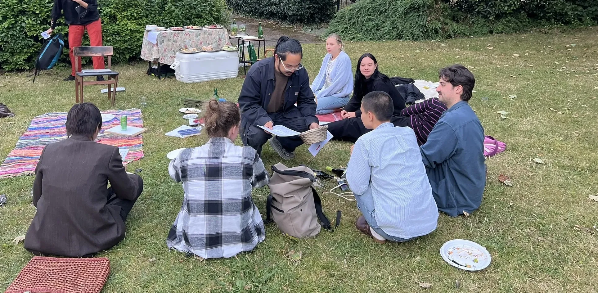 Kevin working together with some participants in what seems to be an outdoor supper club picnic workshop.